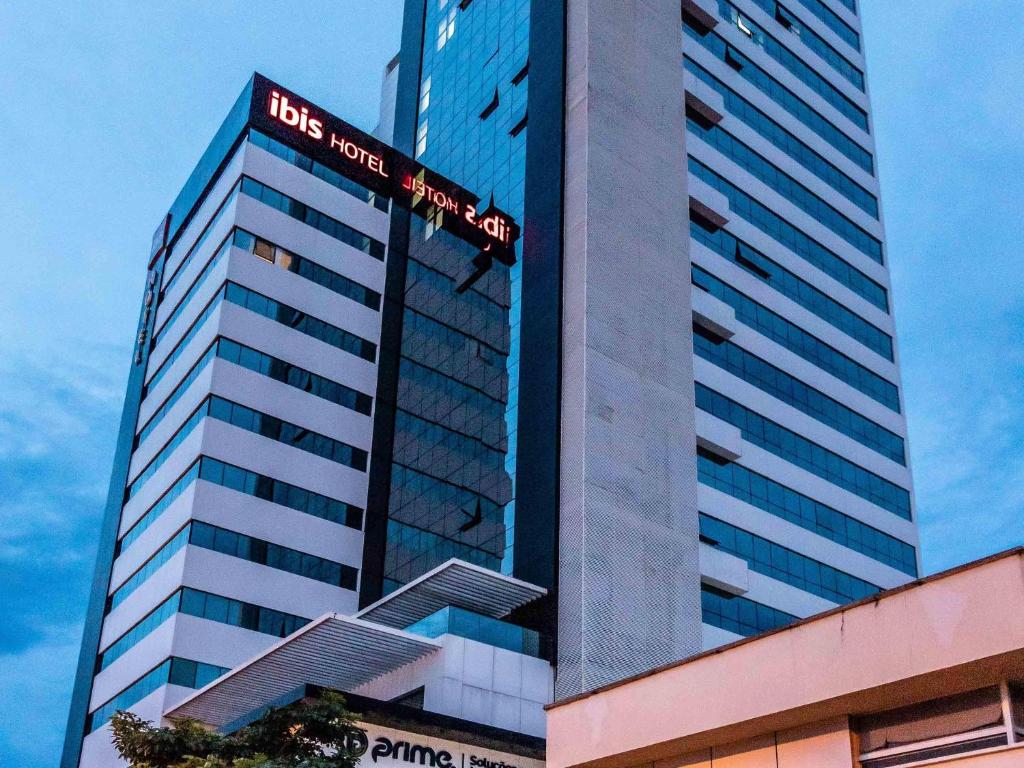 a tall building with a us hotel sign on it at ibis Palmas Avenida JK in Palmas