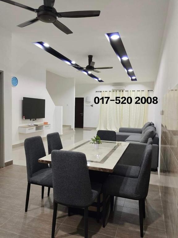 a living room with a table and a couch and a tv at V-Homestay Bentong in Bentong