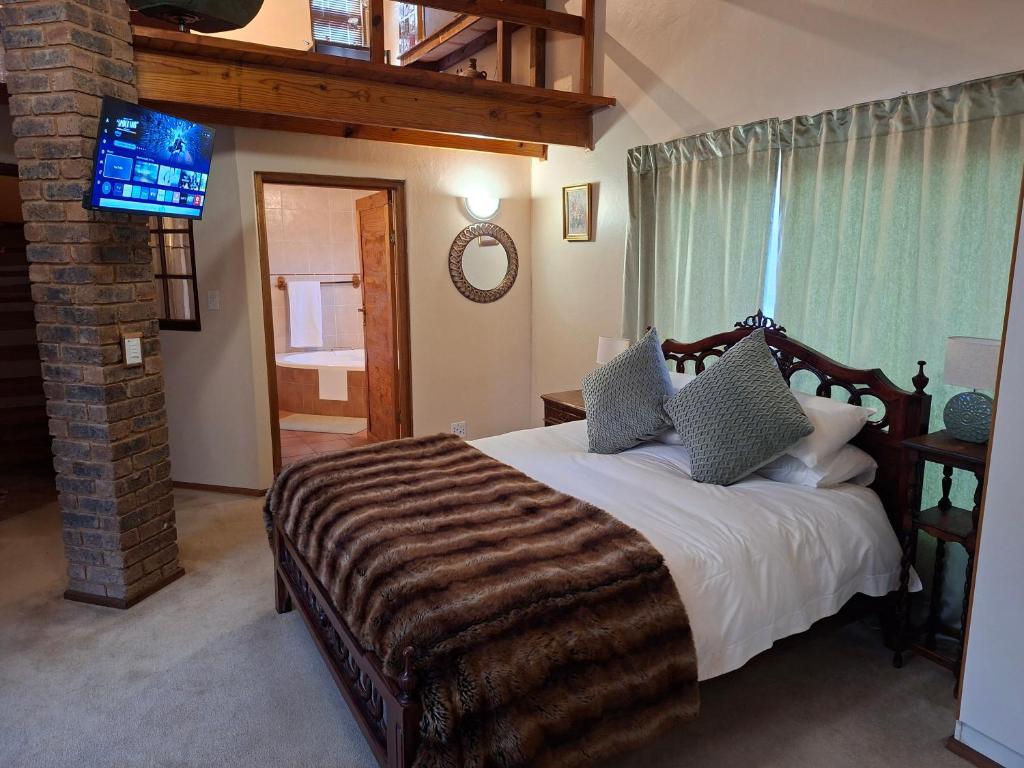 a bedroom with a large bed and a television at De Windmolen in Centurion
