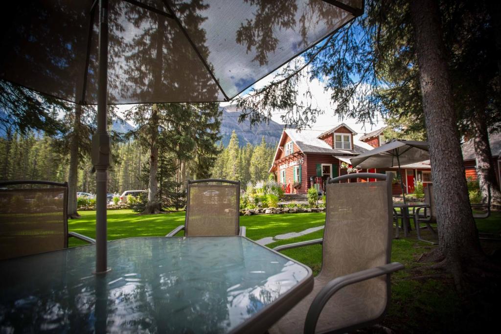 a table and chairs under an umbrella in front of a house at Paradise Lodge and Bungalows in Lake Louise