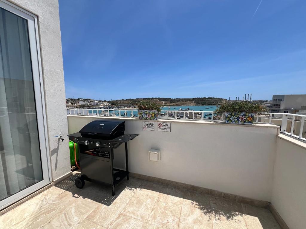 a balcony with a desk on the side of a building at Seaview Marsaxlokk Apartment Eye of Osiris in Marsaxlokk