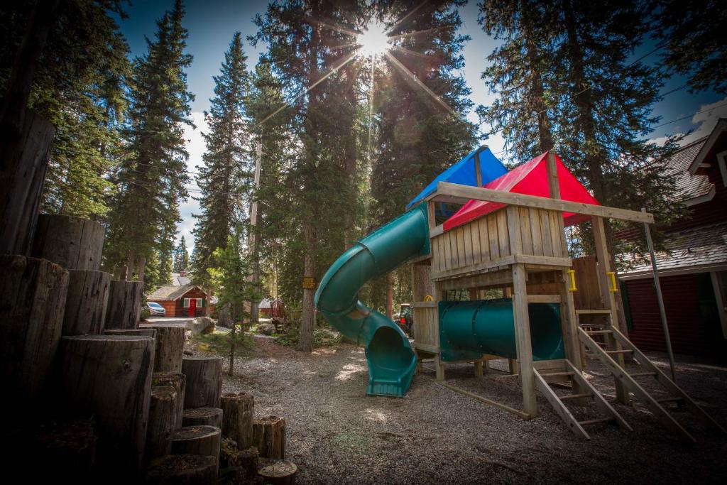 a playground with a slide and a house at Paradise Lodge and Bungalows in Lake Louise