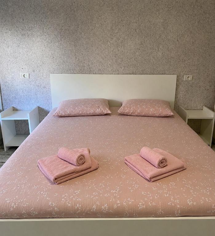 a bed with two pink towels on top of it at Casa Elena in Constanţa