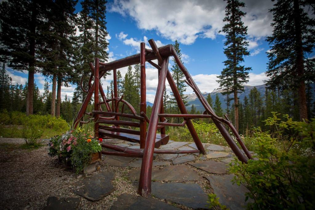 a wooden playground in the middle of a forest at Paradise Lodge and Bungalows in Lake Louise