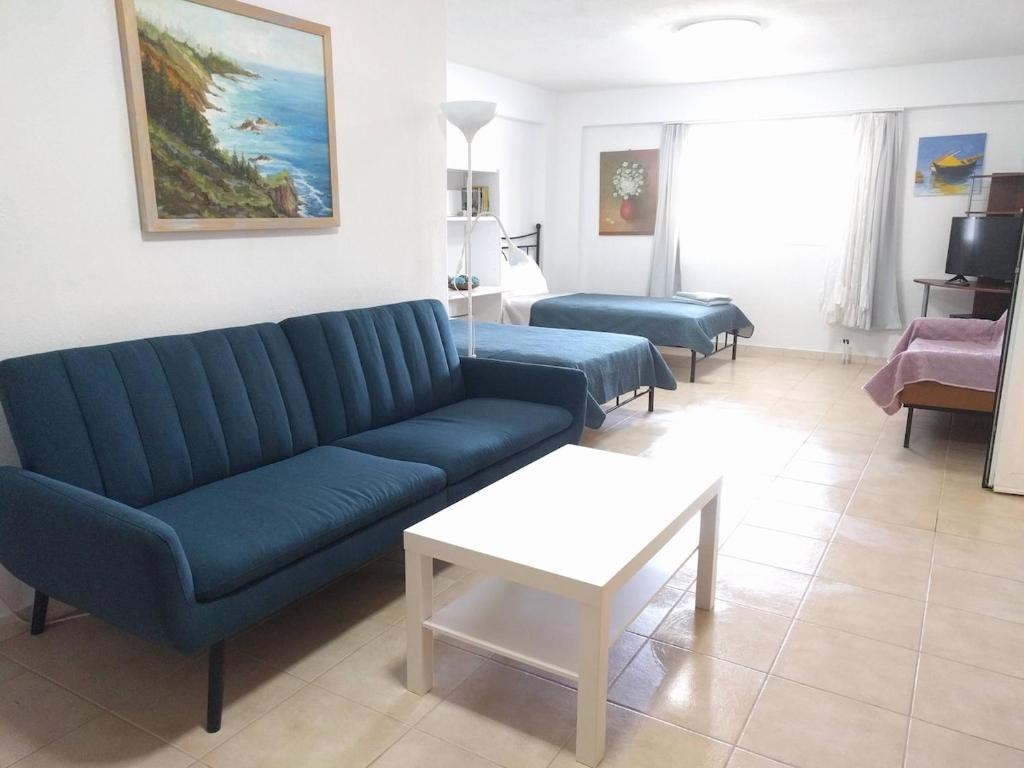 a living room with a blue couch and a table at Almond Apartments Ground Floor Apt in Ofrínion