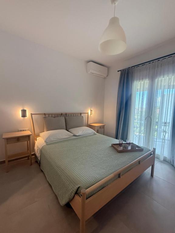 a bedroom with a large bed and a large window at Sofia Studios in Benitses