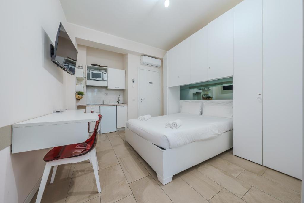 a white bedroom with a bed and a desk at Cristel Apartment - 15 min da Milano in Cormano