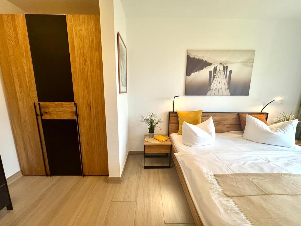 a bedroom with a bed and a wooden door at Oewern Diek App 02 in Wustrow