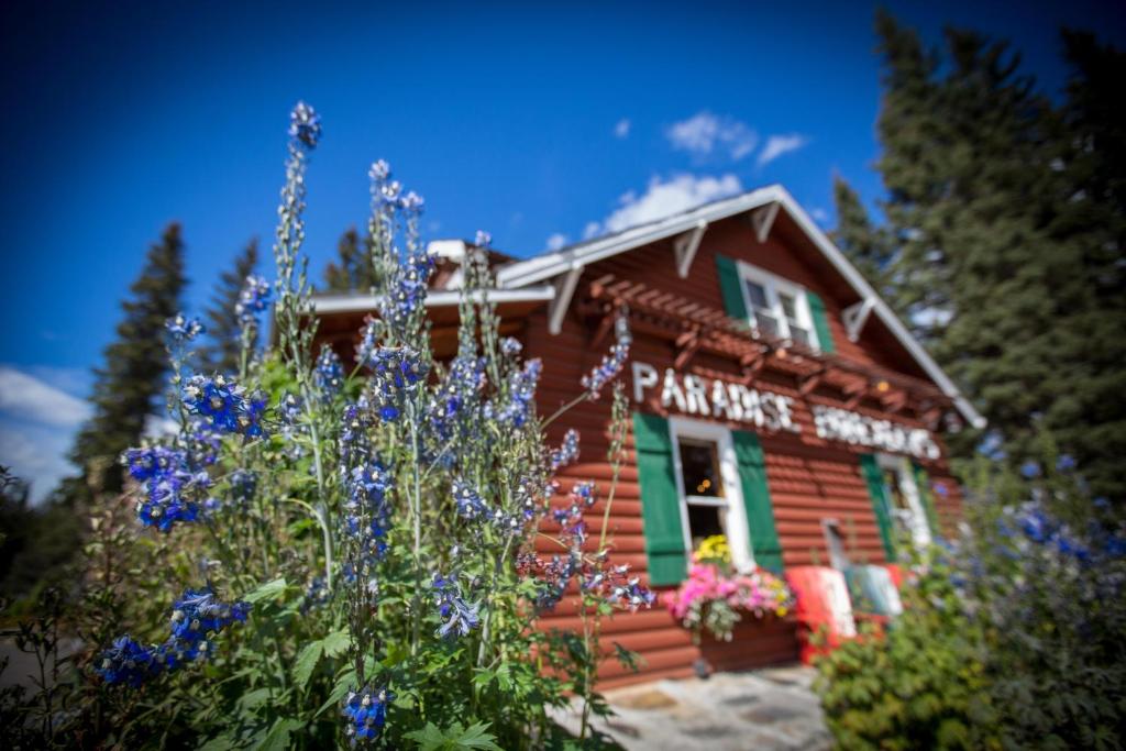 a log cabin with flowers in front of it at Paradise Lodge and Bungalows in Lake Louise