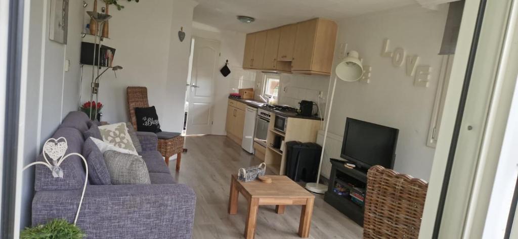 a living room with a purple couch and a kitchen at Abija in Putten