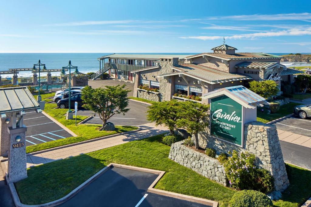 a building with a sign in front of a parking lot at Cavalier Oceanfront Resort in San Simeon