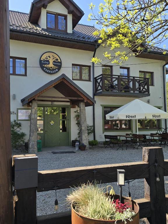 a building with a green door and a patio at Karczma Karnasów in Cisna