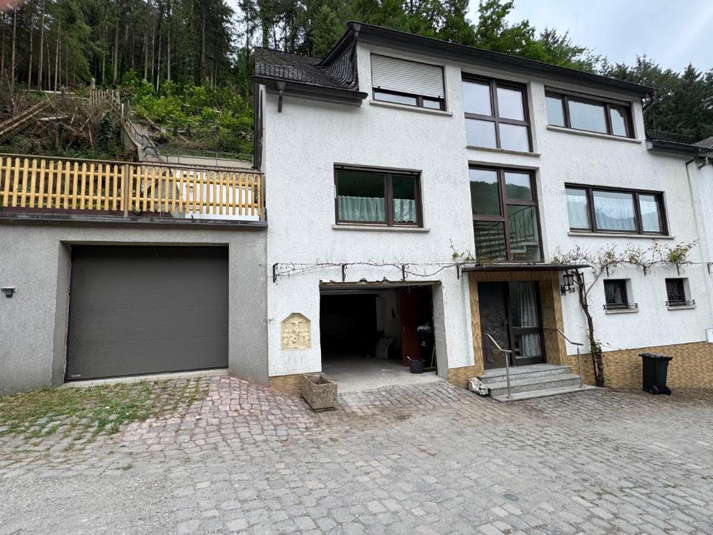 a large white house with a garage at Ferienhaus zum Wasserfall in Bernkastel-Kues