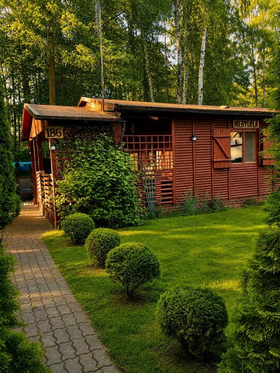 a small cabin in the middle of a yard at Merylula - Domek nad jeziorem in Przydwórz