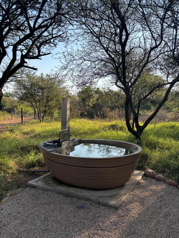 a bath tub sitting on the ground next to a field at Vrede Luxury Tented Camp in Kosmos