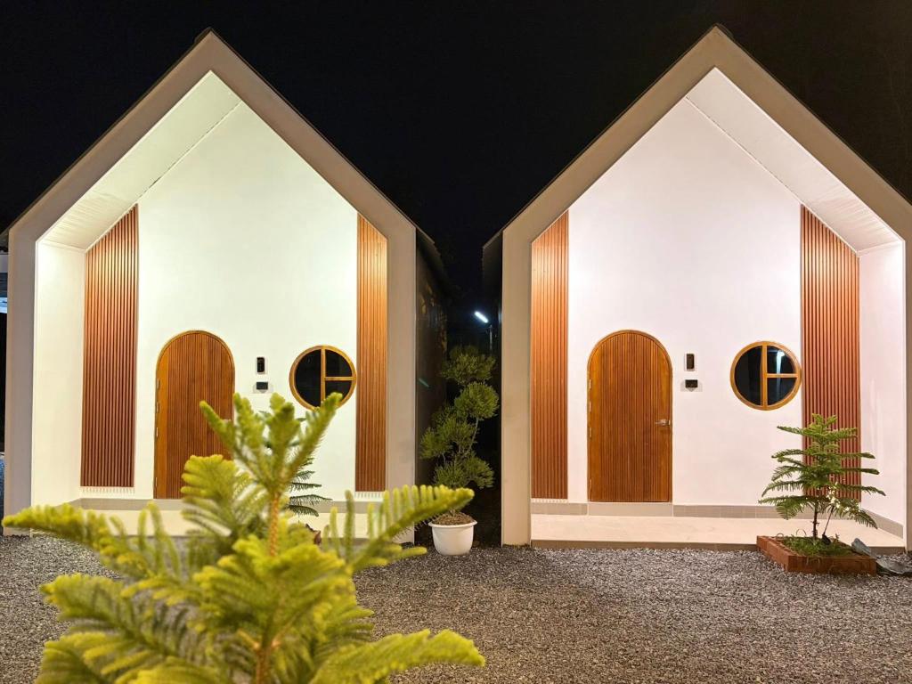 a building with wooden doors with plants in front at แอดโฟร์รีสอร์ท in Ban Phrao