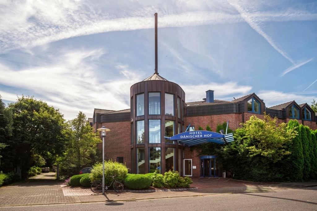 a brick building with a sign on top of it at Pure Hotel Dänischer Hof in Altenholz