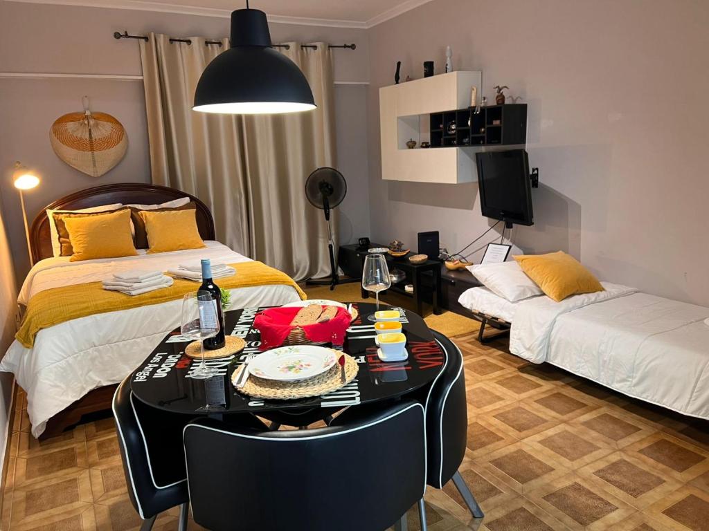 a bedroom with a bed and a table and a couch at Studio Central na Amadora, Vista da Cidade, Sossegado, a 15min de Lisboa in Amadora