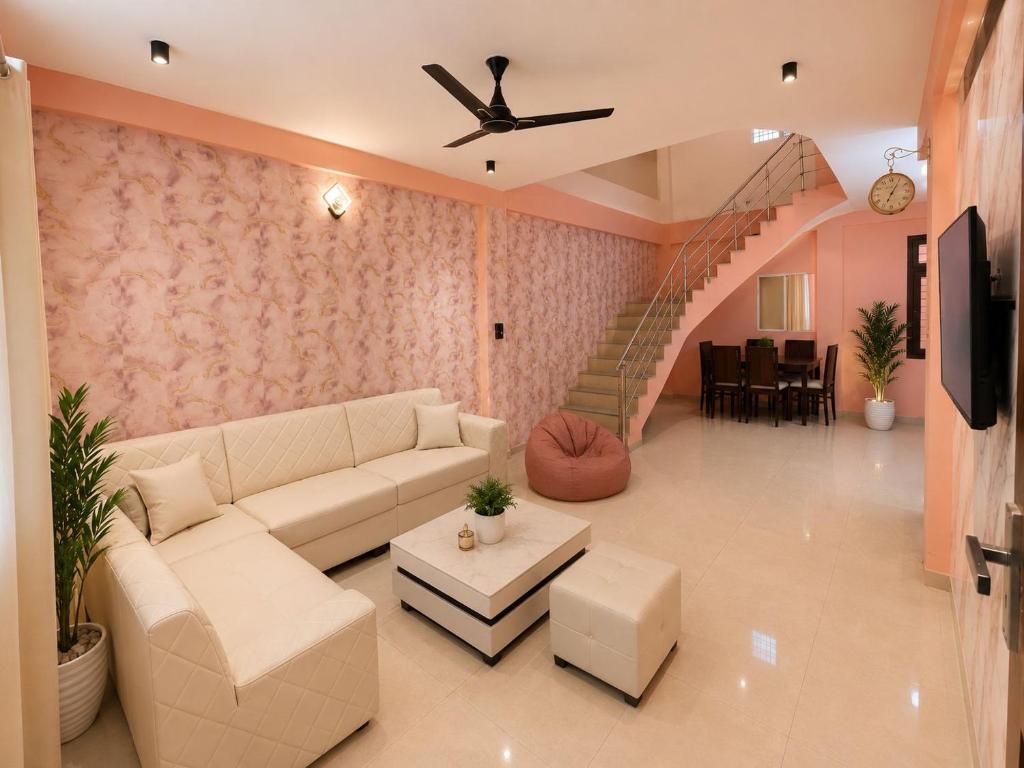 a living room with a couch and a staircase at Villa by Stay Junction in Indore
