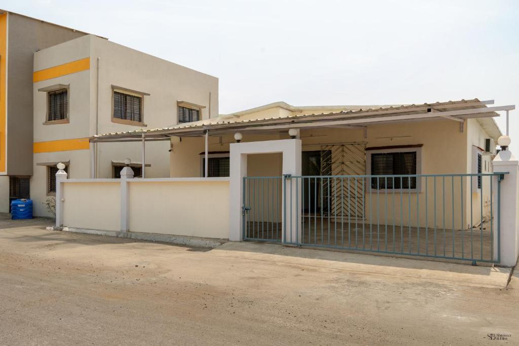 a white building with a gate in front of it at Ananda Villa in Igatpuri