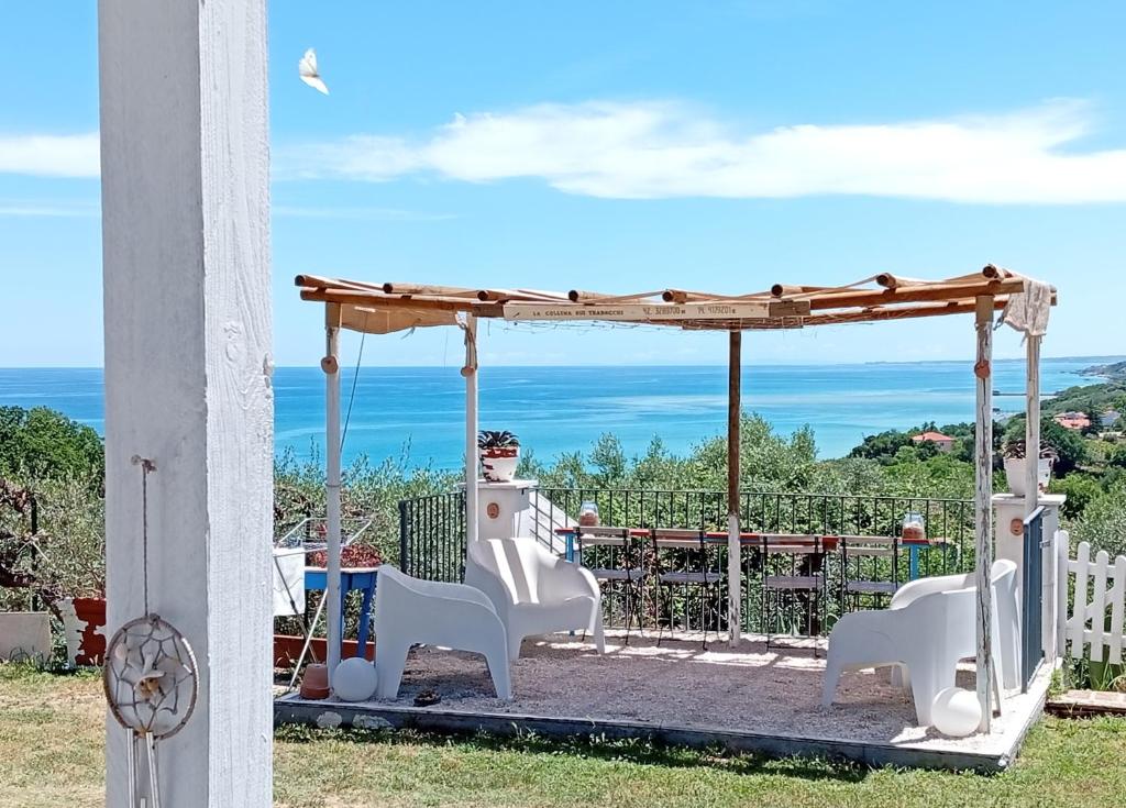 a gazebo with two white chairs and the ocean at La collina sui trabocchi in Ortona