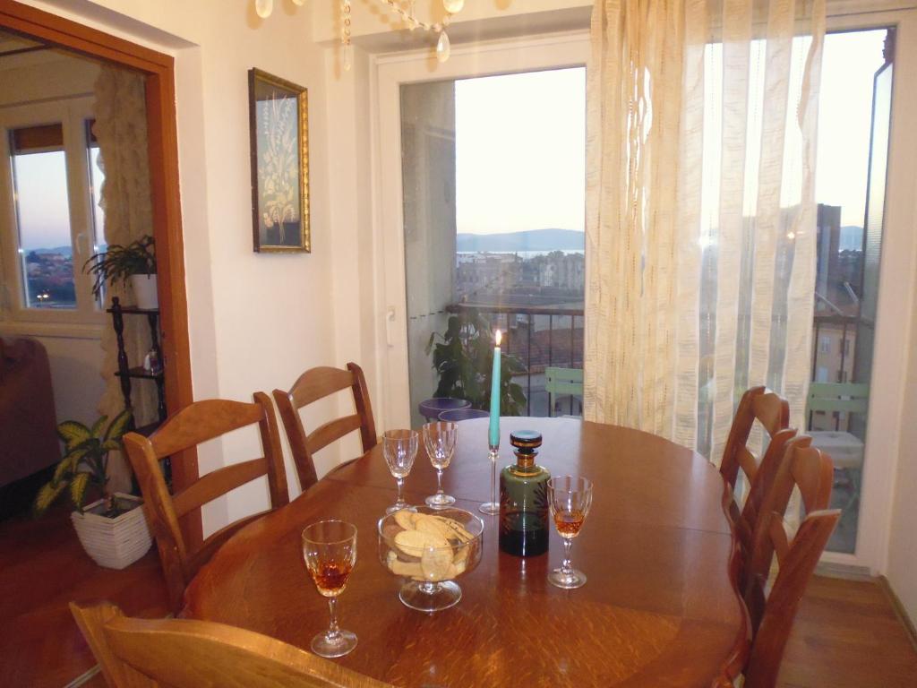 uma mesa de madeira com copos de vinho e uma vela. em Apartment Sime em Zadar