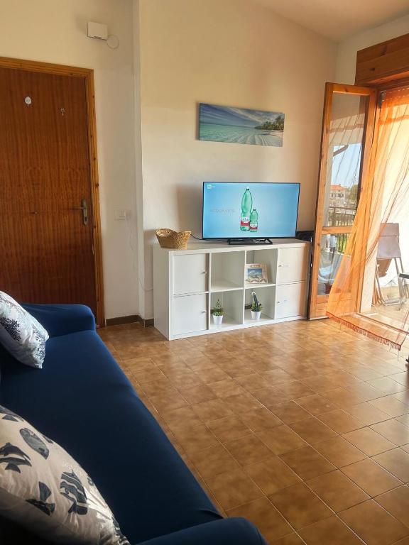 a living room with a blue couch and a tv at Casa COMER GRISOLIA in Cirella