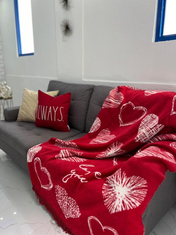 a red blanket sitting on top of a couch at Private Oasis with Jacuzzi & Pool for Two in Ciales