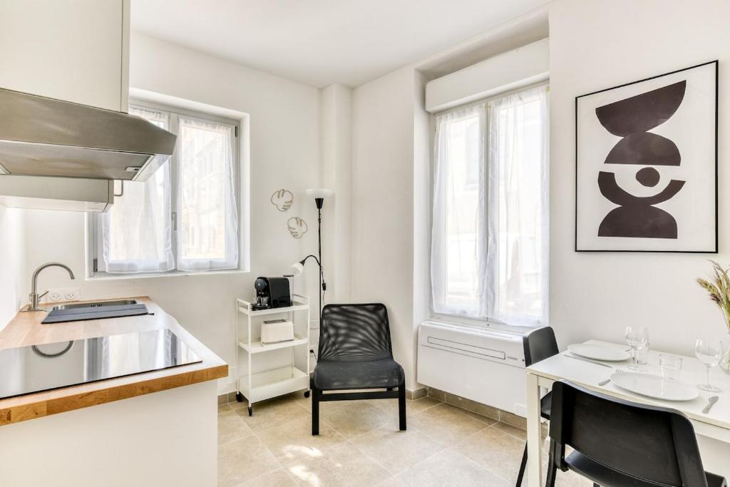 a kitchen with a table and a chair in a room at La Petite Maison - T1 Bis in Peyriac-de-Mer