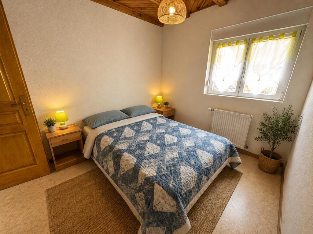 a bedroom with a bed and two lamps and a window at Gîte Arnica in Soultzeren