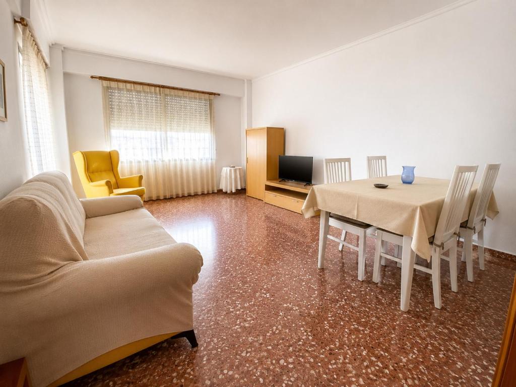 a living room with a table and a couch at Maripatri Solo Familias Serviplaya!!! in Playa de Xeraco