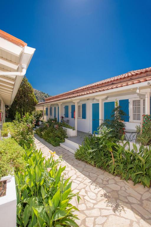 a row of houses with blue doors and plants at Blue White House in Kalamitsi