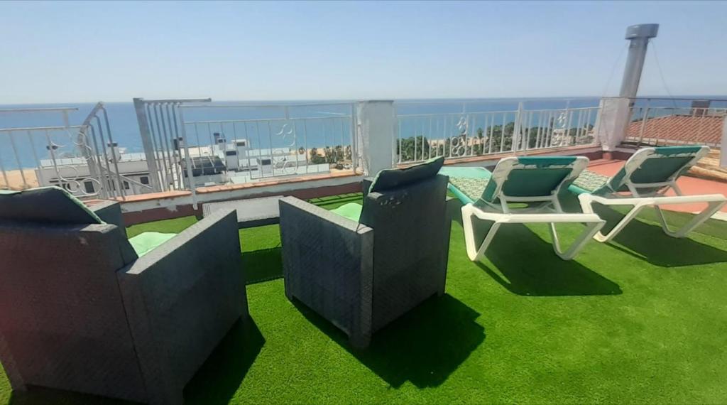 a balcony with chairs and a view of the ocean at terraza al mar in Pineda de Mar