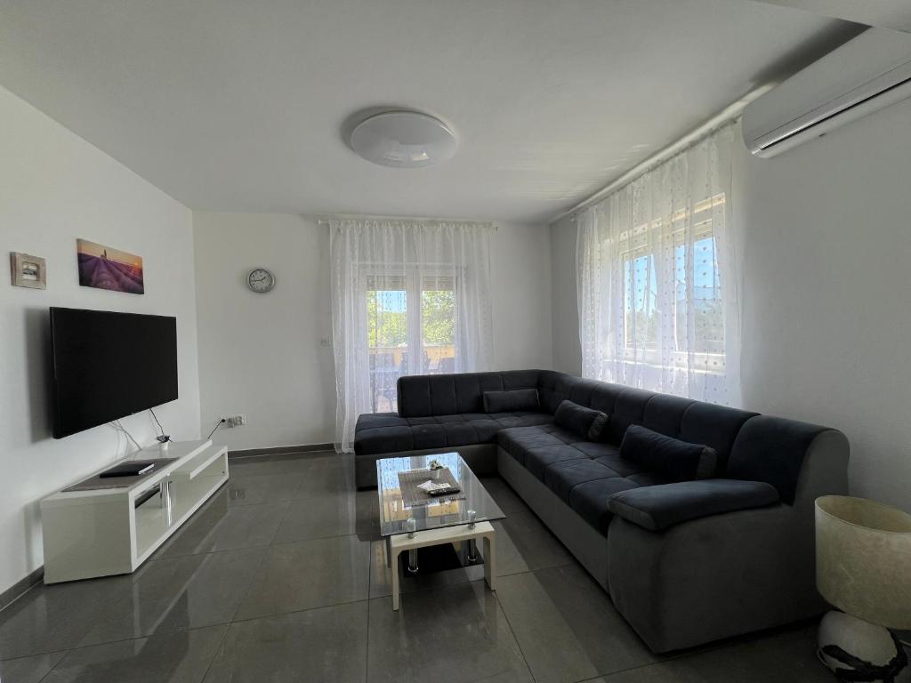 a living room with a couch and a tv at Apartment CReO Loborika in Marčana