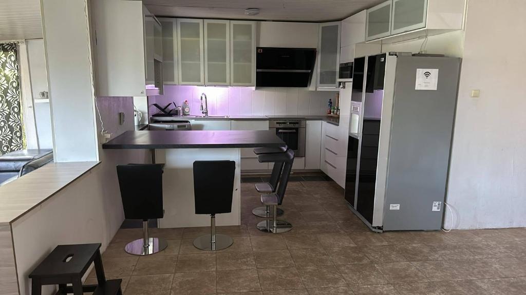a kitchen with a counter and some chairs in it at Sia Home in Vålberg