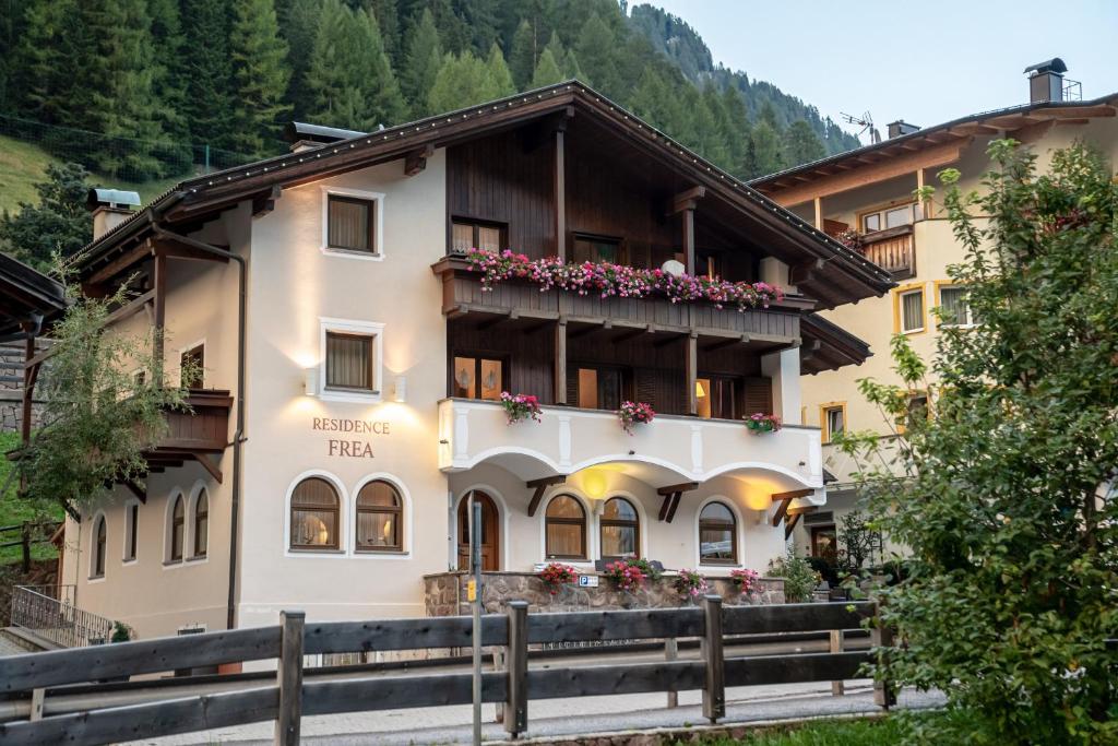 a hotel in the mountains with flowers on the balconies at Residence Frea in Selva di Val Gardena