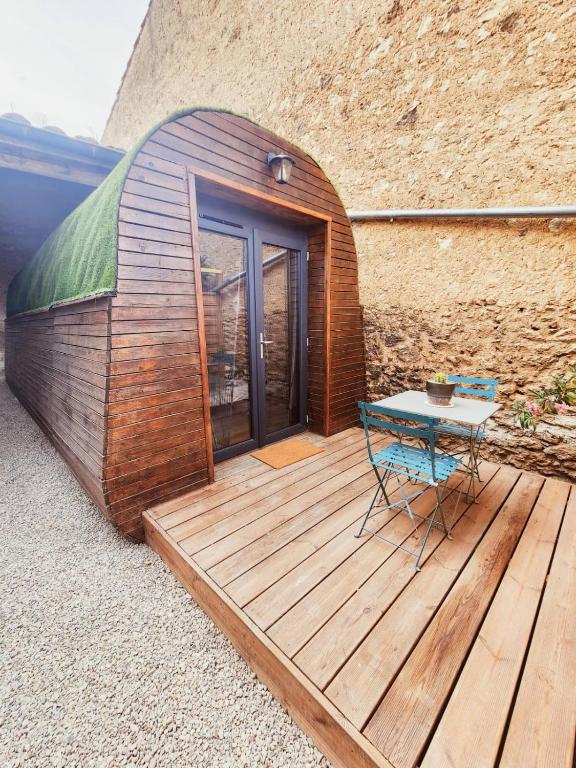 a small wooden building with a table on a deck at L'éco-maison tout confort in Puisserguier