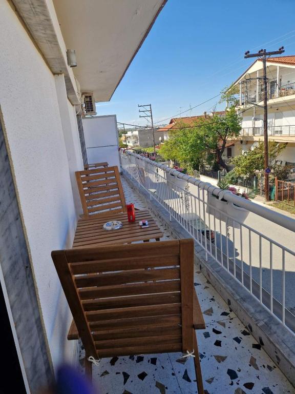 a balcony with two wooden benches on a building at Iraklia Pearl in Nea Irakleia