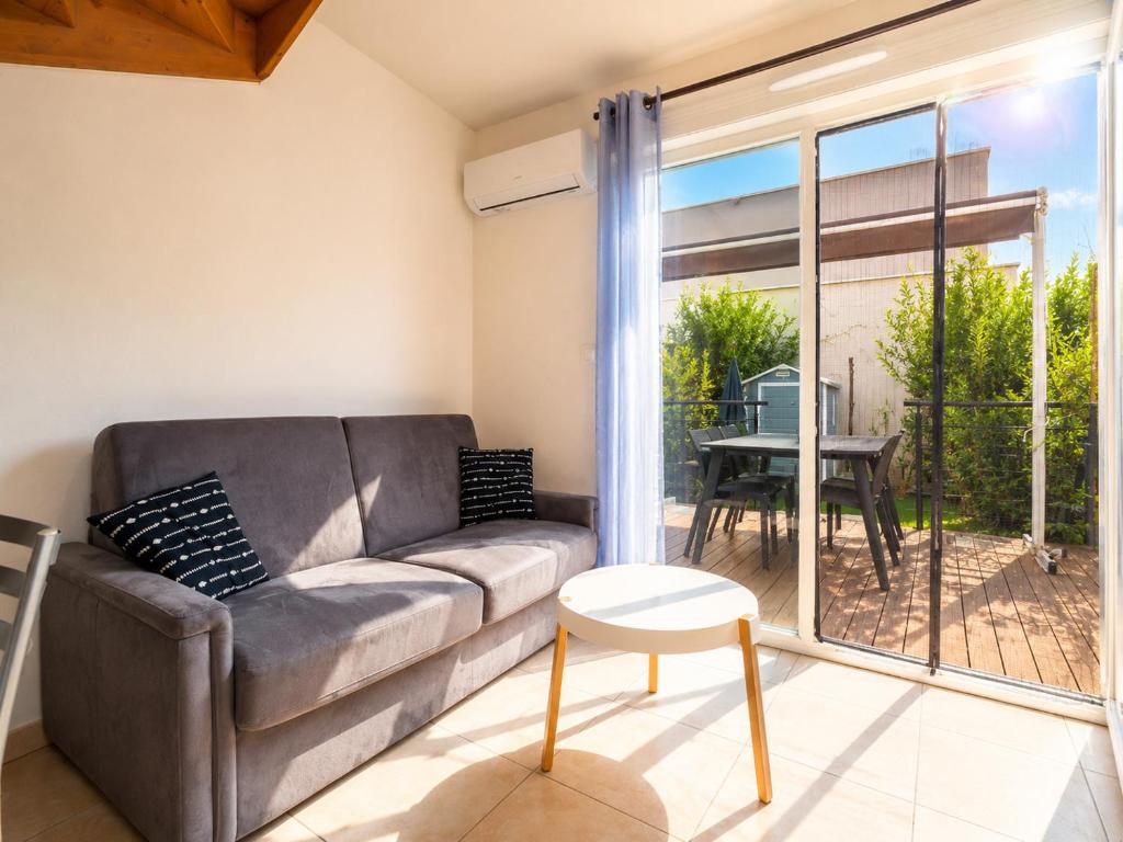 a living room with a couch and a table at La Dune 65 - Villa 3P6 in Sérignan