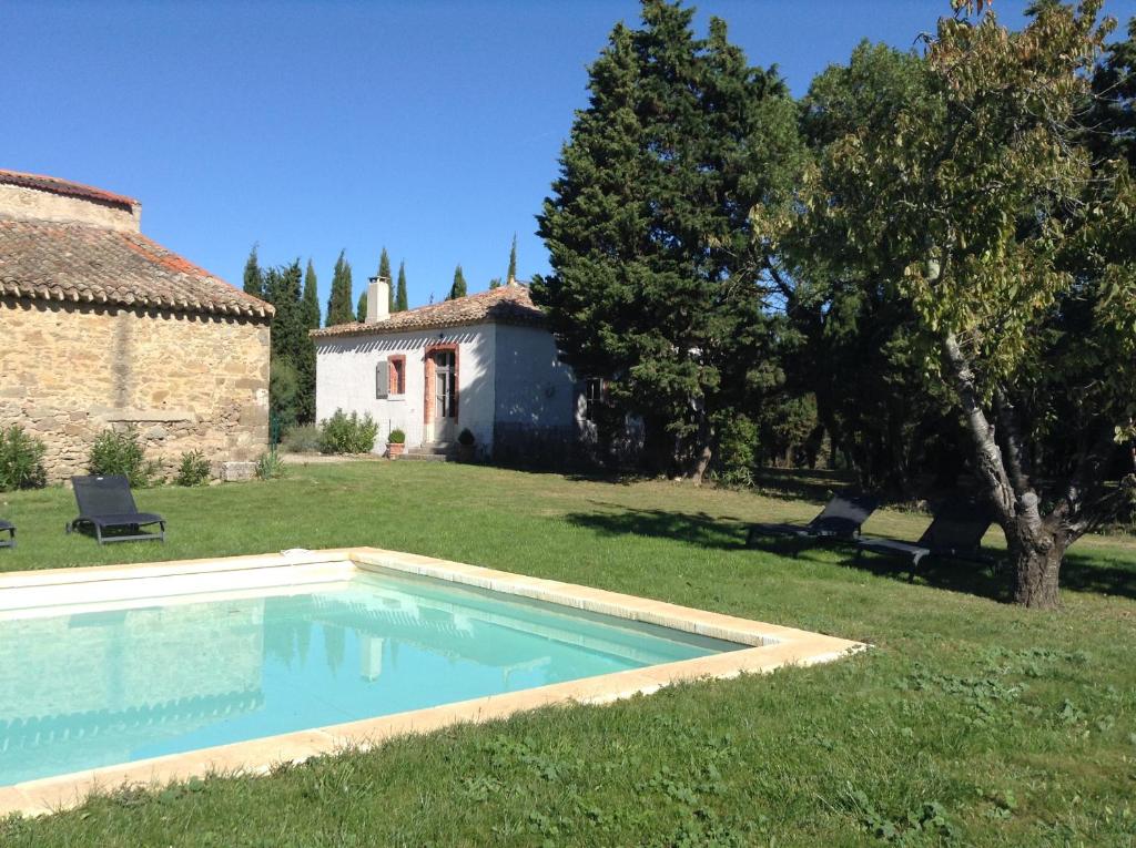 a swimming pool in a yard next to a house at Pavillon de Villefrancou in Montlaur