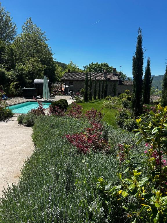 a garden with a swimming pool and flowers at B&B Borgo Scola Paradise View in Vimignano
