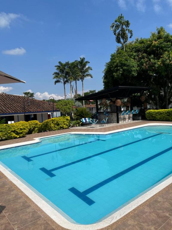 a swimming pool at a resort with blue water at Hotel Campestre Santa Lucia in Montenegro