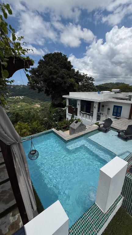 a large swimming pool in front of a house at Private Oasis with Jacuzzi & Pool for Two in Ciales