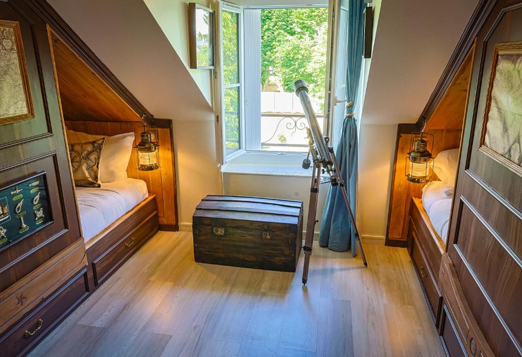 a small room with a bed and a window at Le refuge des explorateurs - chasse au trésor in La Flèche