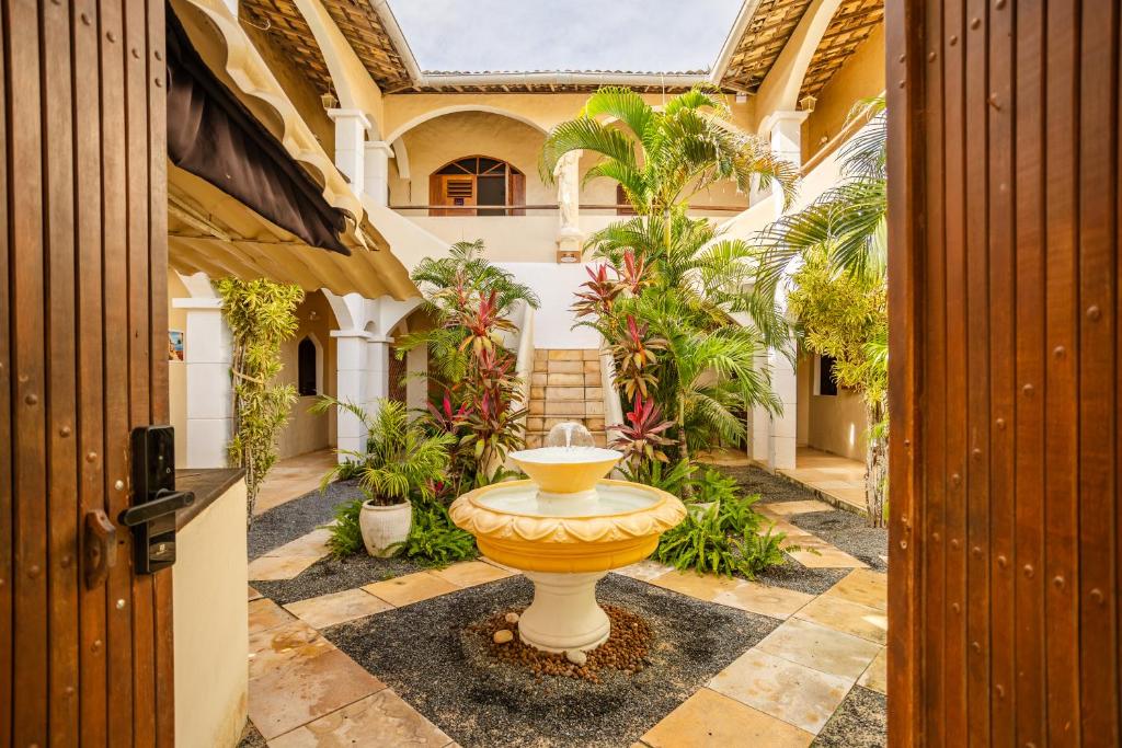 a courtyard with a fountain in the middle of a building at Villa Medina Oasis in Jericoacoara