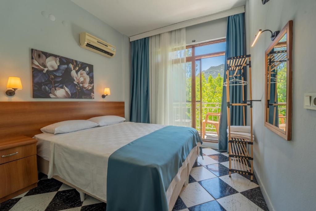 a bedroom with a bed and a window at The Turunç INN Otel in Turunç