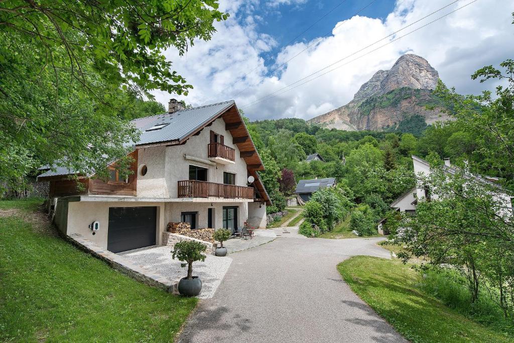 a house with a mountain in the background at Duplex la source Amelie in Saint-Pancrasse