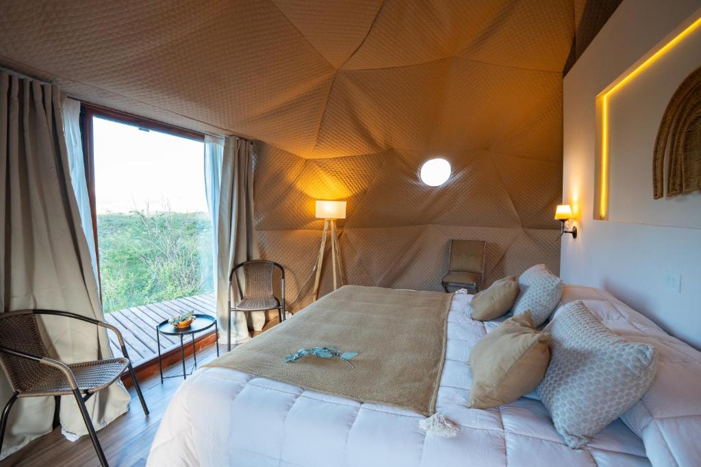a bedroom with a large bed in a tent at Sentio Camps - All Inclusive in Cabra Corral