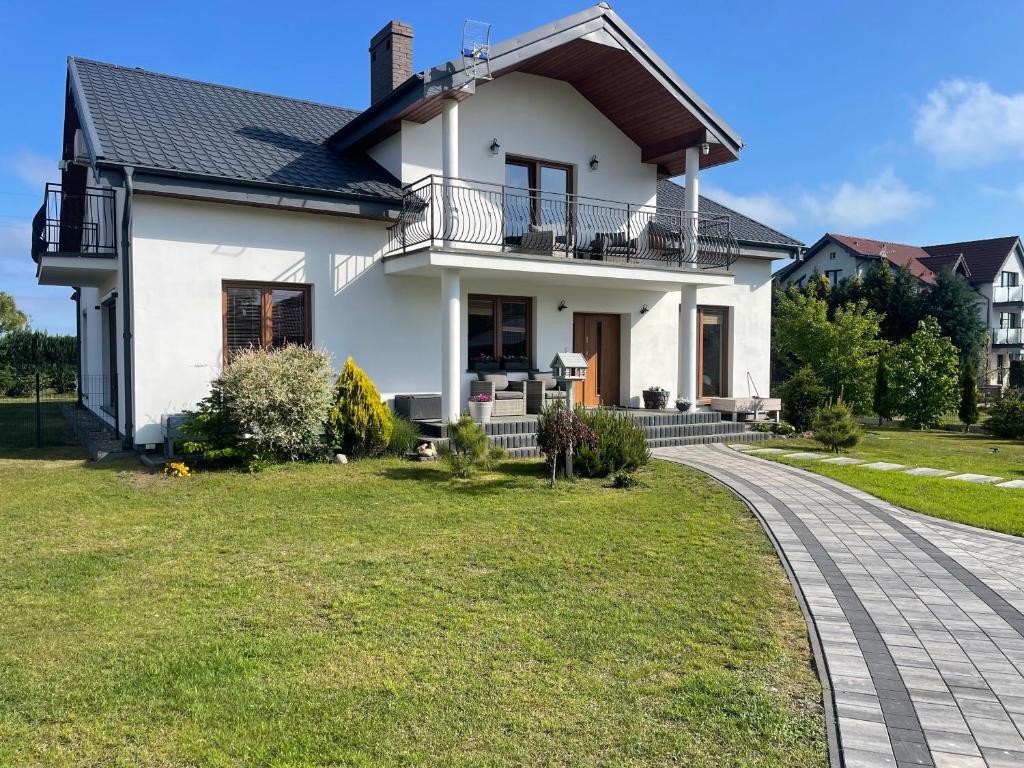 a white house with a walkway at Gregorek in Ostrowo