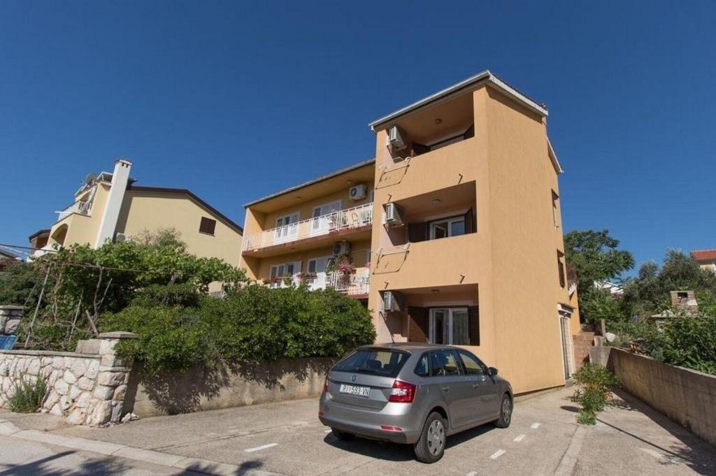a car parked in a parking lot in front of a building at Apartments Marija in Cres